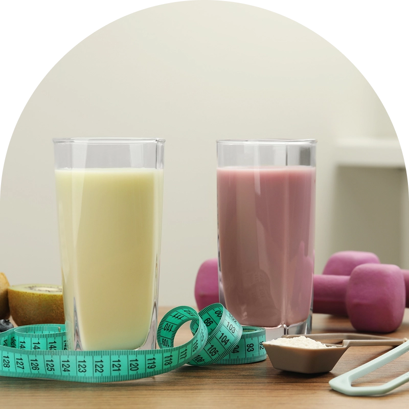 Protein shakes, measuring tape, and dumbbells on table. Protein shakes, measuring tape, and dumbbells on table.